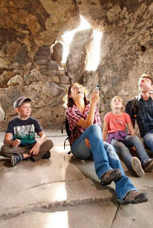 familie in höhle taschenlampe
